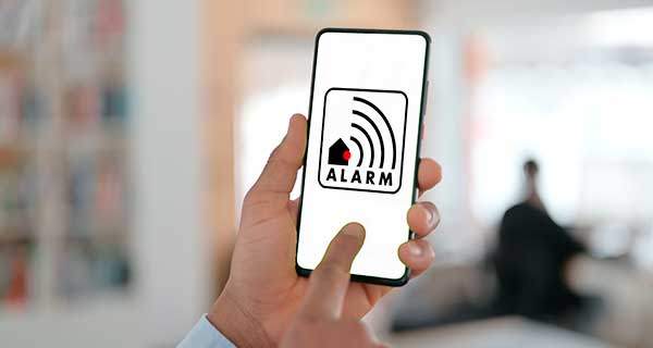 Mand med app hvor man kan se et piktogram for en alarm